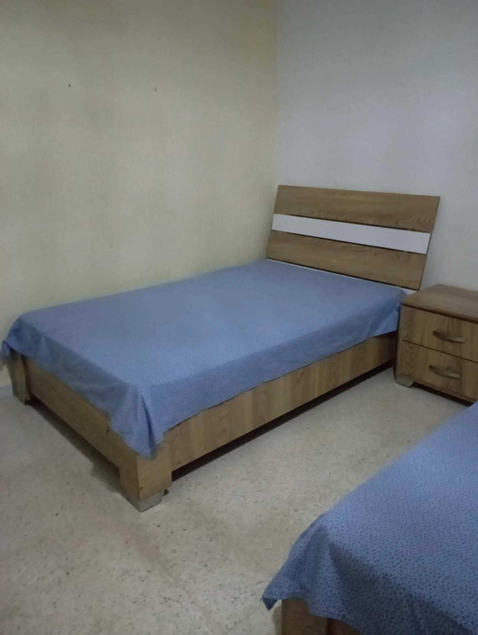 Deux lits avec matelas en bon état et une table de nuit