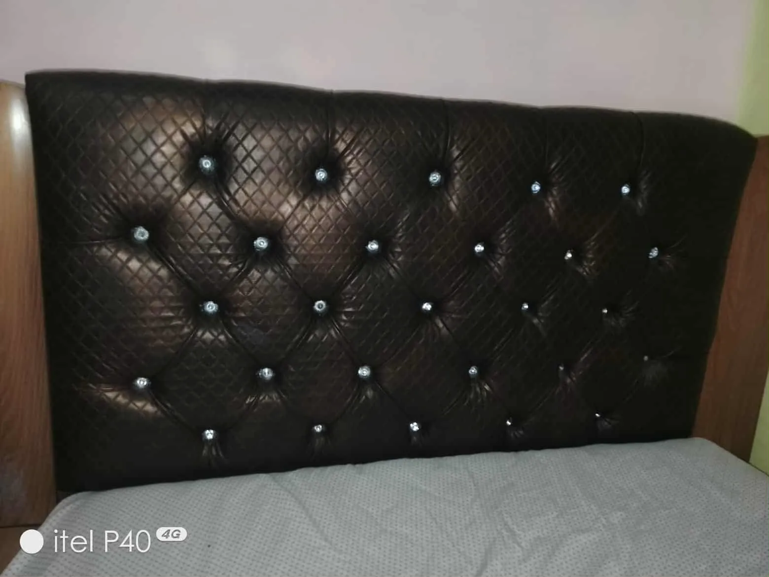 Un lit avec matelas en bon état et une table de nuit