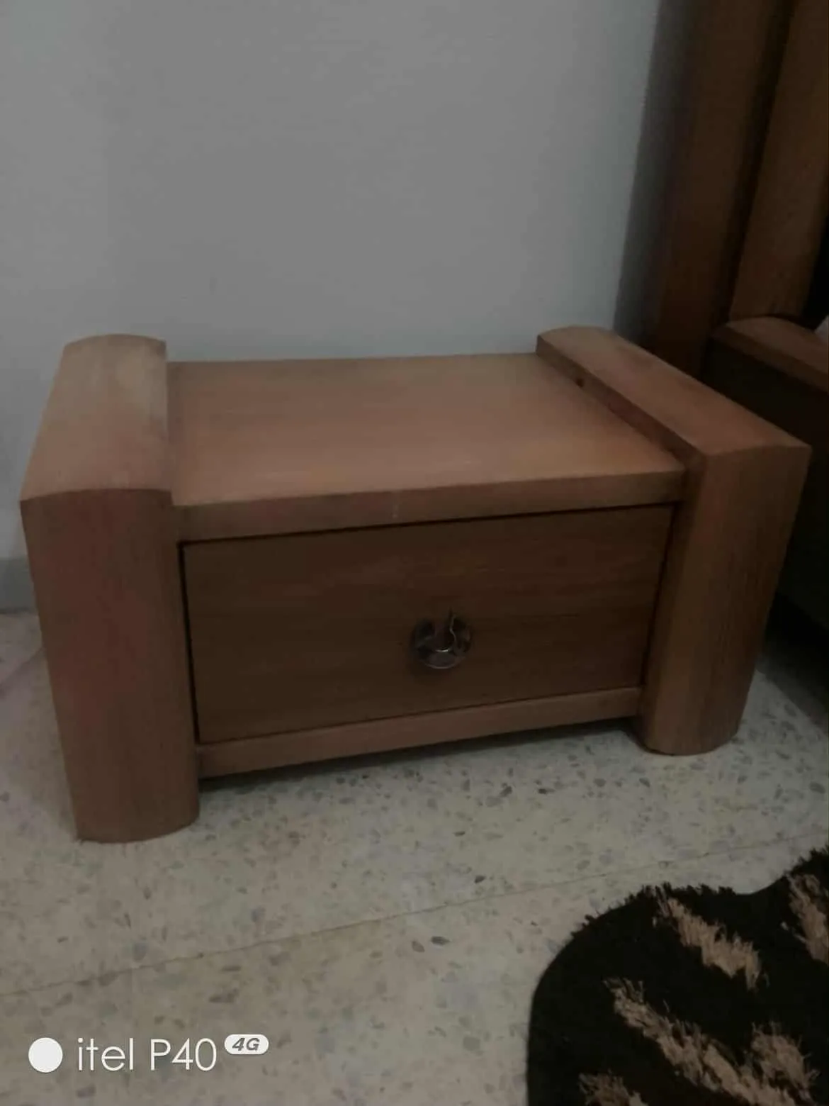 Un lit avec matelas en bon état et une table de nuit