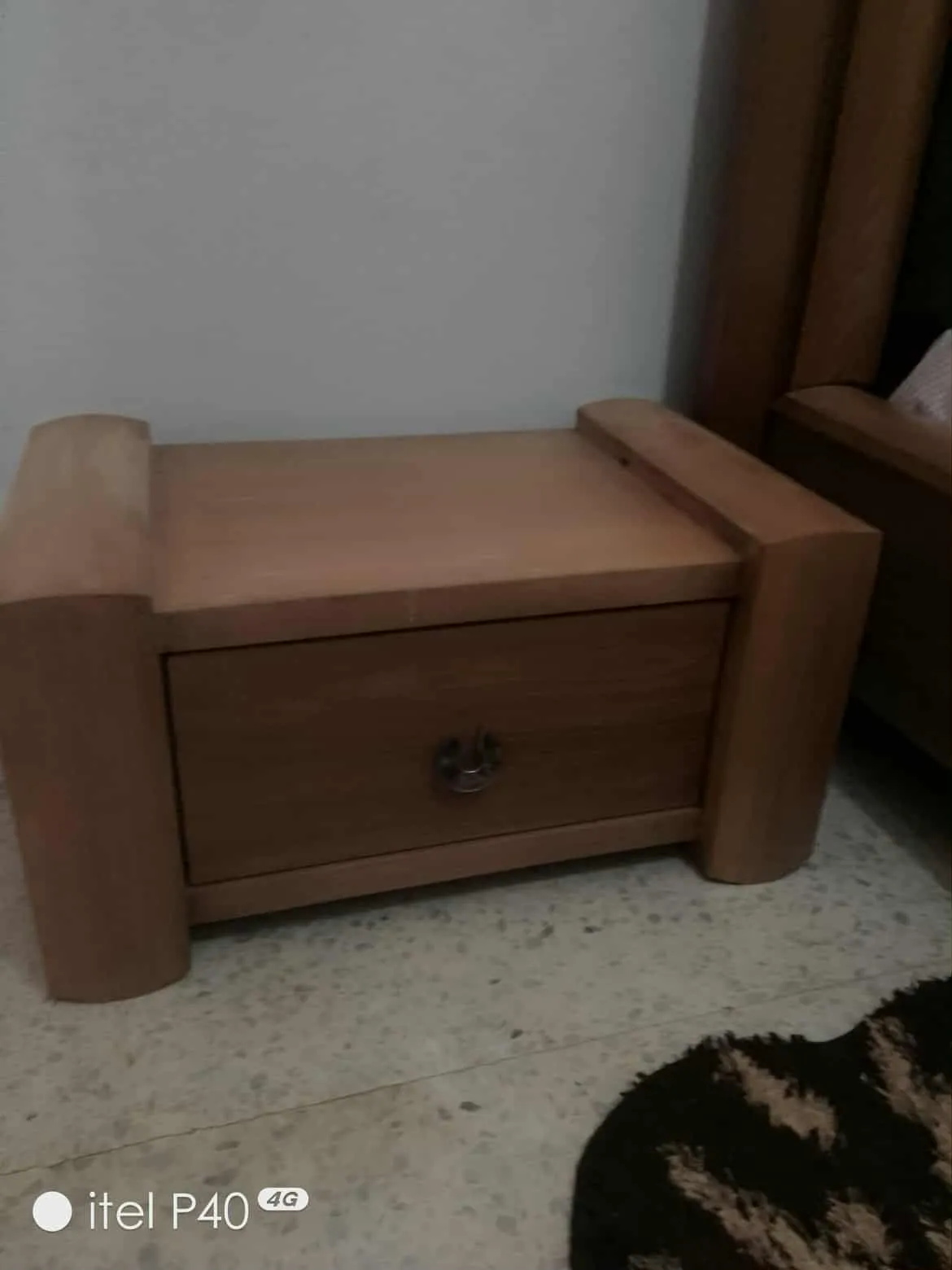 Un lit avec matelas en bon état et une table de nuit