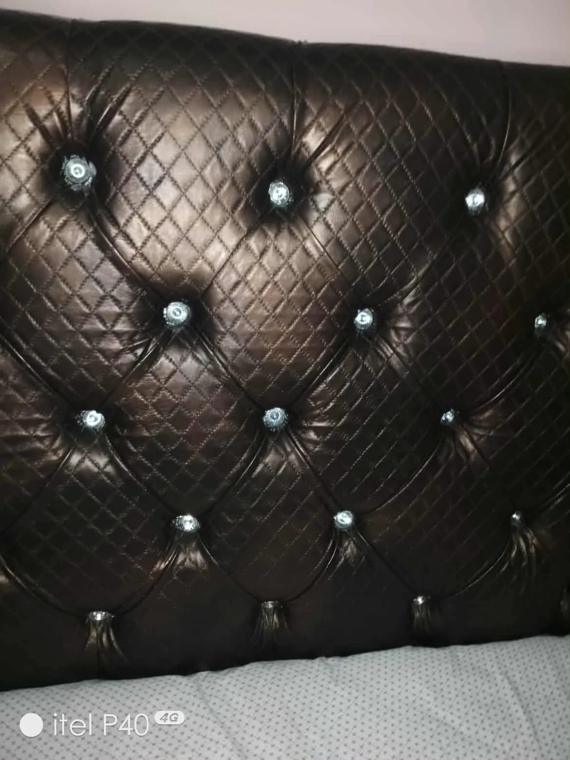 Un lit avec matelas en bon état et une table de nuit